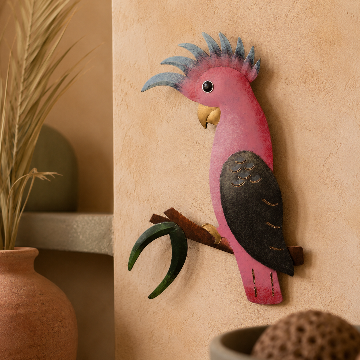 Decorative wall art of a pink parrot on a beige wall with plants in the background